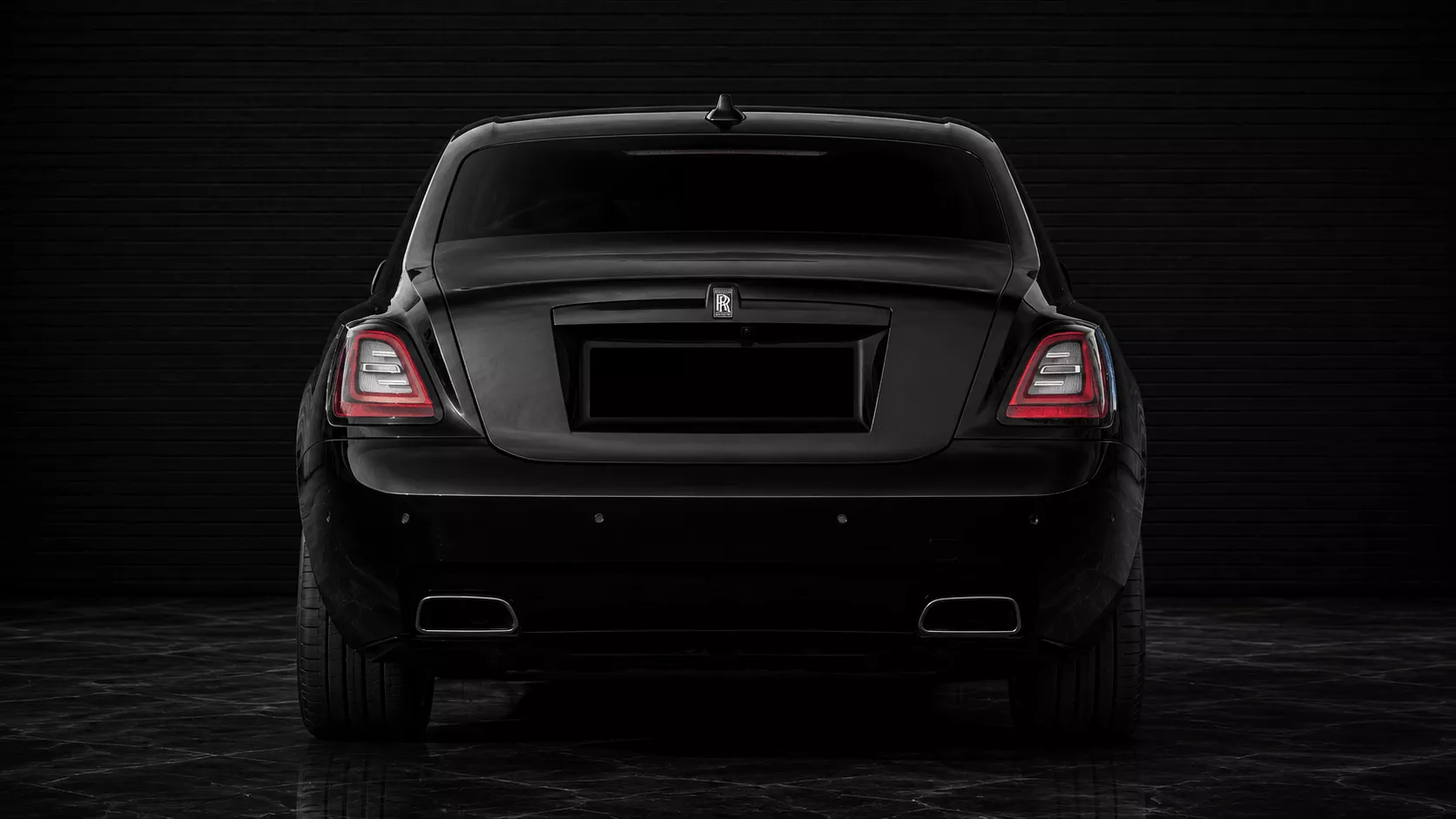 Black Rolls-Royce Ghost Series III rear studio view with blacked-out number plate for premium private chauffeur transport in Sydney